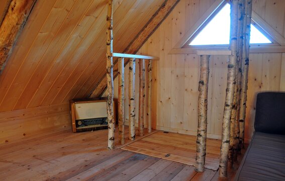 wooden interior triangular window . old radio solid birch railing.