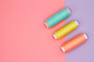 Top view of multi-colored sewing reels on a colored background. Hobby concept