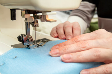 Woman sews on a sewing machine