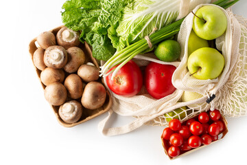 Plastic free. Healthy food. Fresh vegetables and fruits in eco-friendly reusable cotton bags on white background. Top view.
