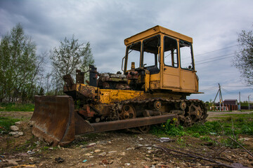 Fototapeta na wymiar Broken tractor on tracks in the field