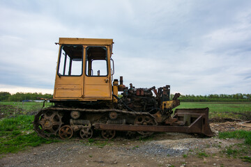 Broken tractor on tracks in the field