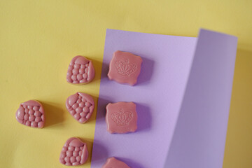 Chocolate candies on a purple and yellow background. Place for photo. Advertising photo.

