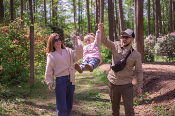 Happy Family walking in botanical garden. Rhododendron park.