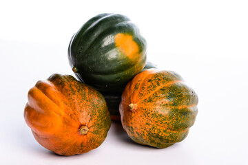 Three green and orange acorn pumpkins on a white background.