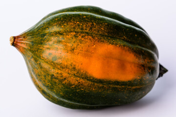 Green and orange acorn pumpkin on a white background.
