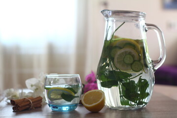 Health care, fitness, healthy eating concept. Fresh cool lemon cucumber drink with water, cocktail, detox drink, lemonade in a glass jug and a glass.