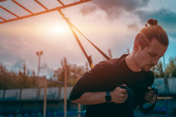 yound sporty athlete or bodybuilder has fitness workout with trx outdoor