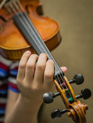 Young student's hands practicing the violin