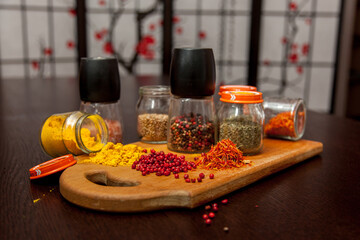 Salt, pepper and piles of ground spices on the table.