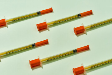 Close up of insulin syringes for diabetes lying diagonally isolated over light background. Injection medicine concept