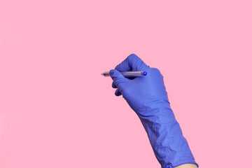Close-up hand in medical latex gloves writing information with a pen.