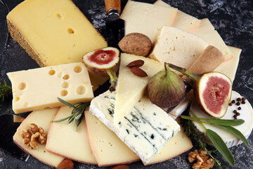Cheese plate served with figs, various cheese on a rustic table