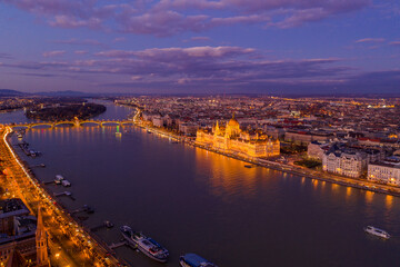 Aerial drone of lighted Hungarian Parliament by Danube river in