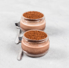 Dessert chocolate cream cottage cheese with cookies, cheesecake without baking in a jar on a light gray background