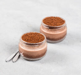 Dessert chocolate cream cheese with cookies, cheesecake in a jar on a light background