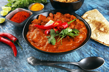 Chicken tikka masala spicy curry meat food in pot with rice and naan bread. indian food on table