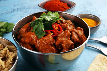 Chicken tikka masala spicy curry meat food in pot with rice and naan bread. indian food on table