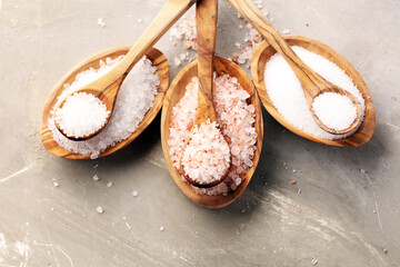 Sea salt and himalayan on spoon. Crystals of salt on background