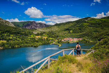Una chica observa el pueble en la otra orilla del lago.