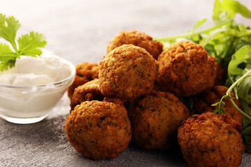 roasted falafel chickpeas patties with garlic yogurt sauce on table