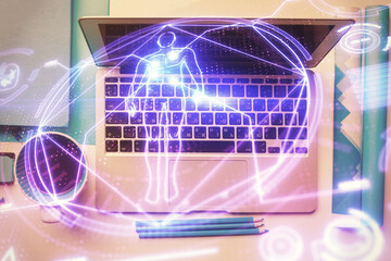 Education hologram drawings over computer on the desktop background. Top view. Multi exposure.