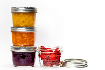 Fototapeta na wymiar Three Home Made Preserves Jam Jars and a Canning Jar of Fresh Raspberries