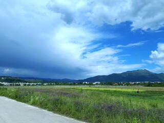 Fototapeta na wymiar Half cloudy half clear sky panorama with mountain in distance