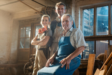 Generations of carpenters in their family business workshop - 360945505