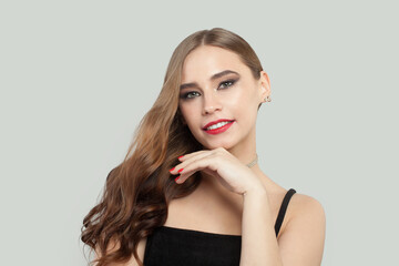 Attractive young woman with red lips makeup and long brown curly hair portrait