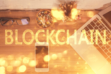 Double exposure of blockchain theme hologram over table with phone. Top view. Crypto technology...