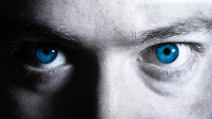 Bright blue eyes of a man close up black and white portrait. Vibrant colorful dramatic eyes background. Window to the soul concept - Powered by Adobe