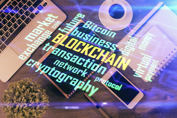 Double exposure of blockchain theme hologram over table with phone. Top view. Crypto technology concept.