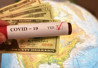 Covid-19 also known as Corona test vial is held over North American Map and combined with US dollars depicting balancing econony with fighting the pandemic