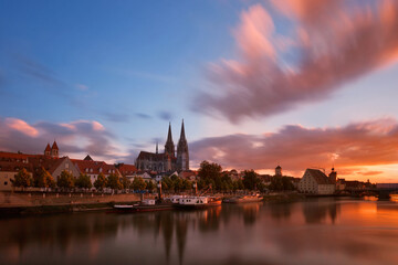 Regensburg am Donauufer mit dramatischen Himmel und spiegelung beim Sonnenuntergang