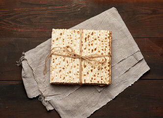 bandaged stack of baked square matzoh on a gray napkin