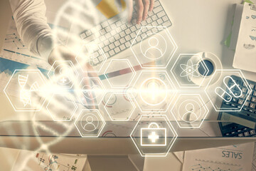 Fototapeta premium Double exposure of man's hands typing over computer keyboard and DNA hologram drawing. Top view. Medical education concept.