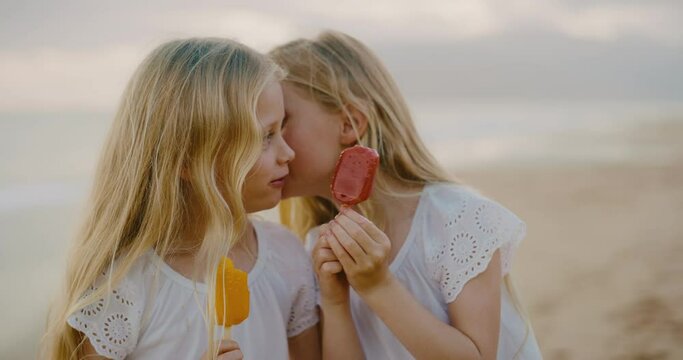 Cute young girls laughing and playing on the beach, summer family lifestyle