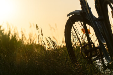 Vintage classic bicycle with nature green backgrounds with water lake river sunset on grass field 