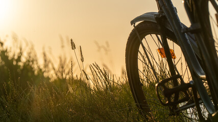 Fototapeta na wymiar Vintage classic bicycle with nature green backgrounds with water lake river sunset on grass field 