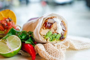 Mexican traditional authentic homemade Burrito with pulled pork beef chili con carne serve with tomato salad and avocado guacamole and dip sauce