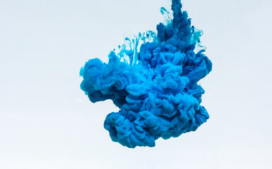Squeezing the blue paint into the water.  Blue  ink in water isolated on white backgroundpaint
