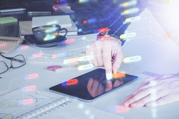Double exposure of man's hand holding and using a digital device and data theme drawing. Technology...
