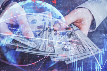 Multi exposure of financial graph drawing hologram and USA dollars bills and man hands. Analysis concept.