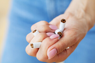 Stop smoking, close up of woman holding a broken cigarette