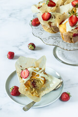 Vanilla muffin with strawberries and cherries with strawberries in the background