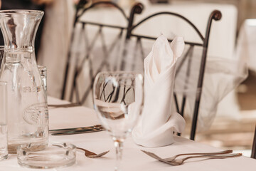 Simple white decorations for wedding venue tables close up with glasses