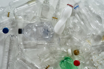 Flatlay composition with different used plastic bottles over white background