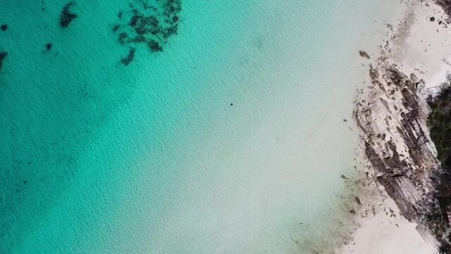 a man swims near a tropical island in clear water. drone video. Gulf of Thailand, Thailand