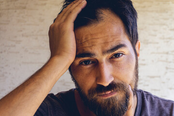 Man using his hand slicking his hair back after facing hair loss problem by taking medicine like zinc and biotin to make his hair grow faster and thicker. Men health and medical concept.